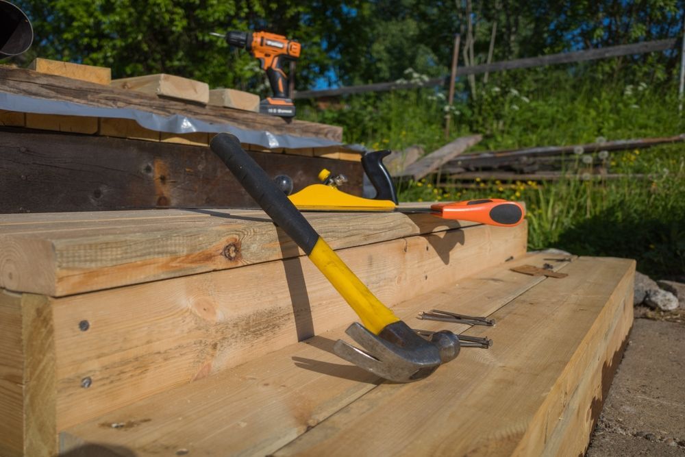 A hammer is sitting on top of a wooden staircase.