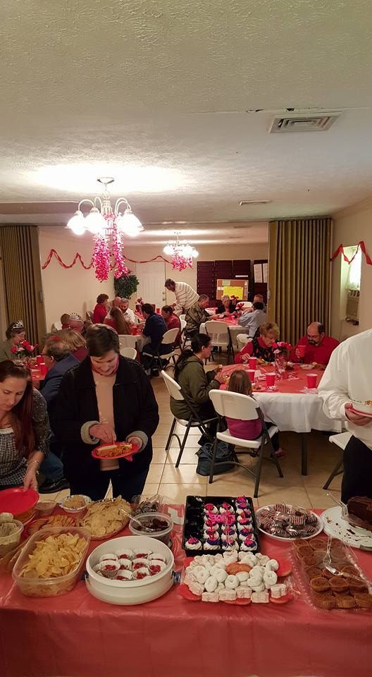 A group of people are sitting at tables in a room eating food.