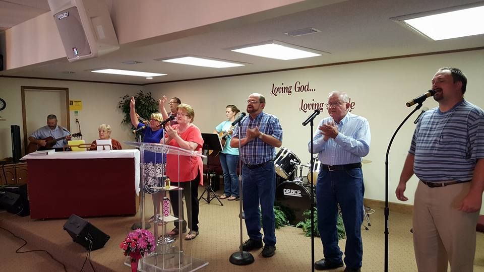 A group of people are singing into microphones in a church.