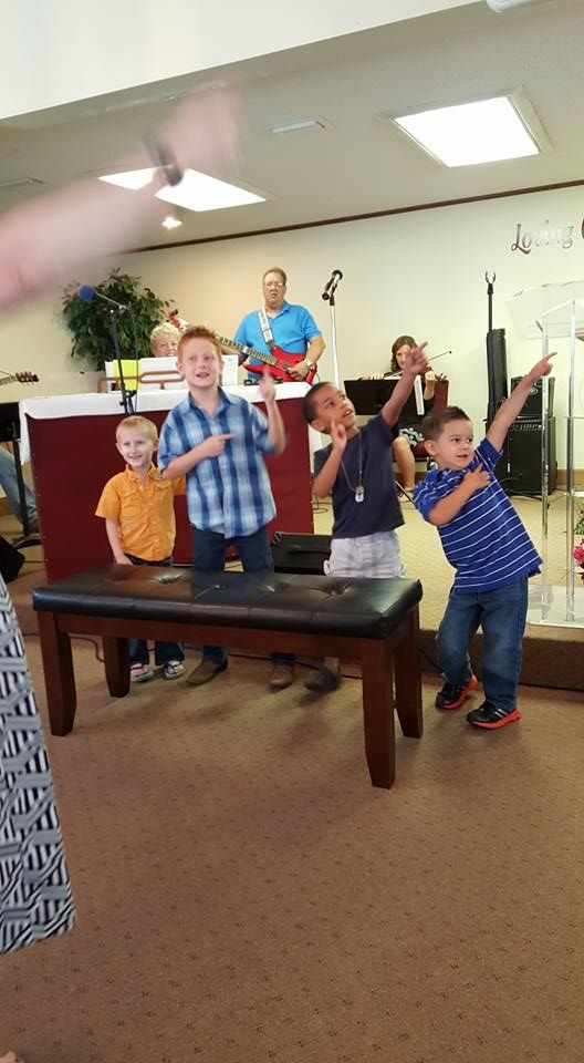 A group of young boys are standing around a table in a room.