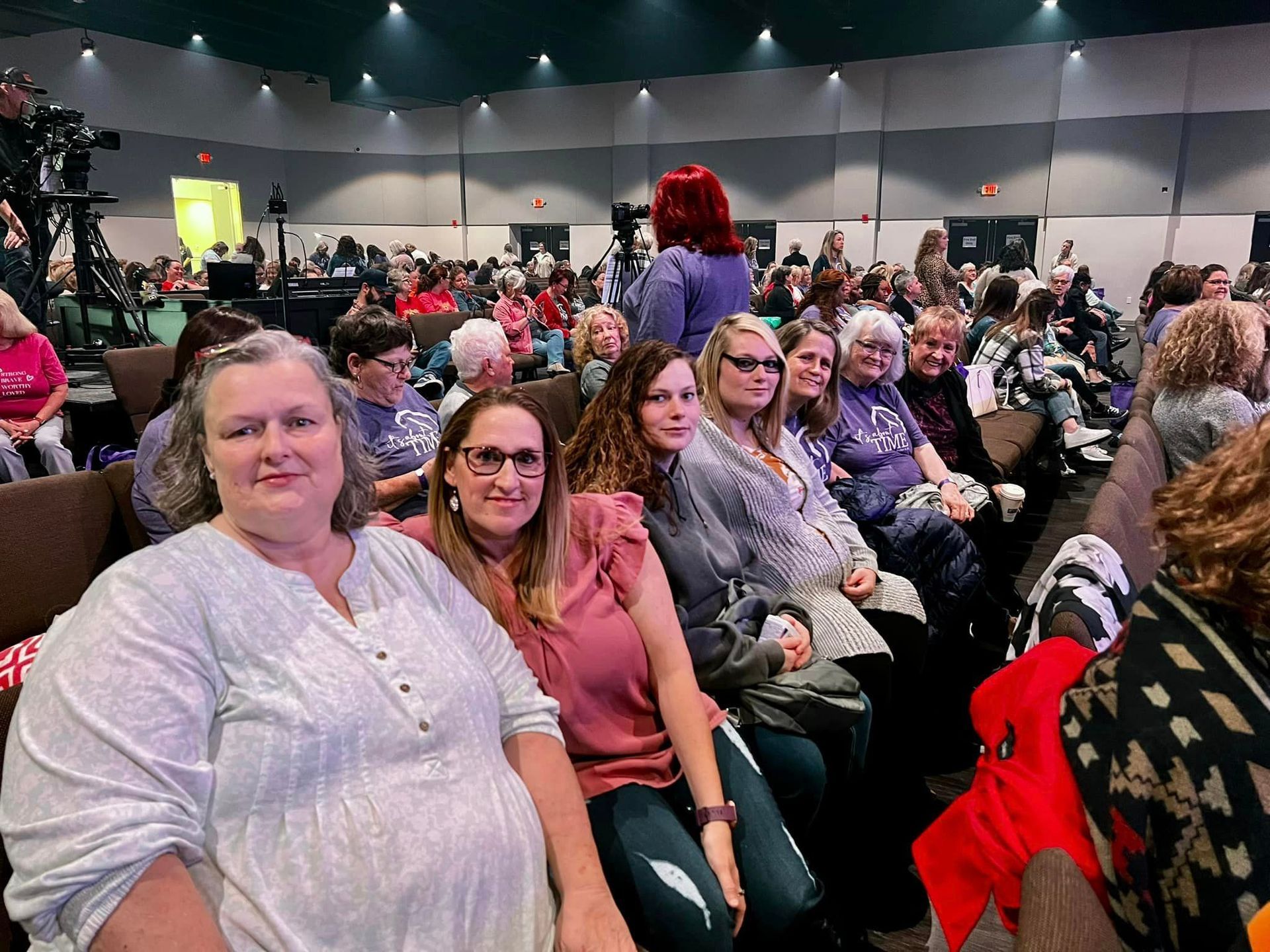 A group of women are sitting in a large auditorium.