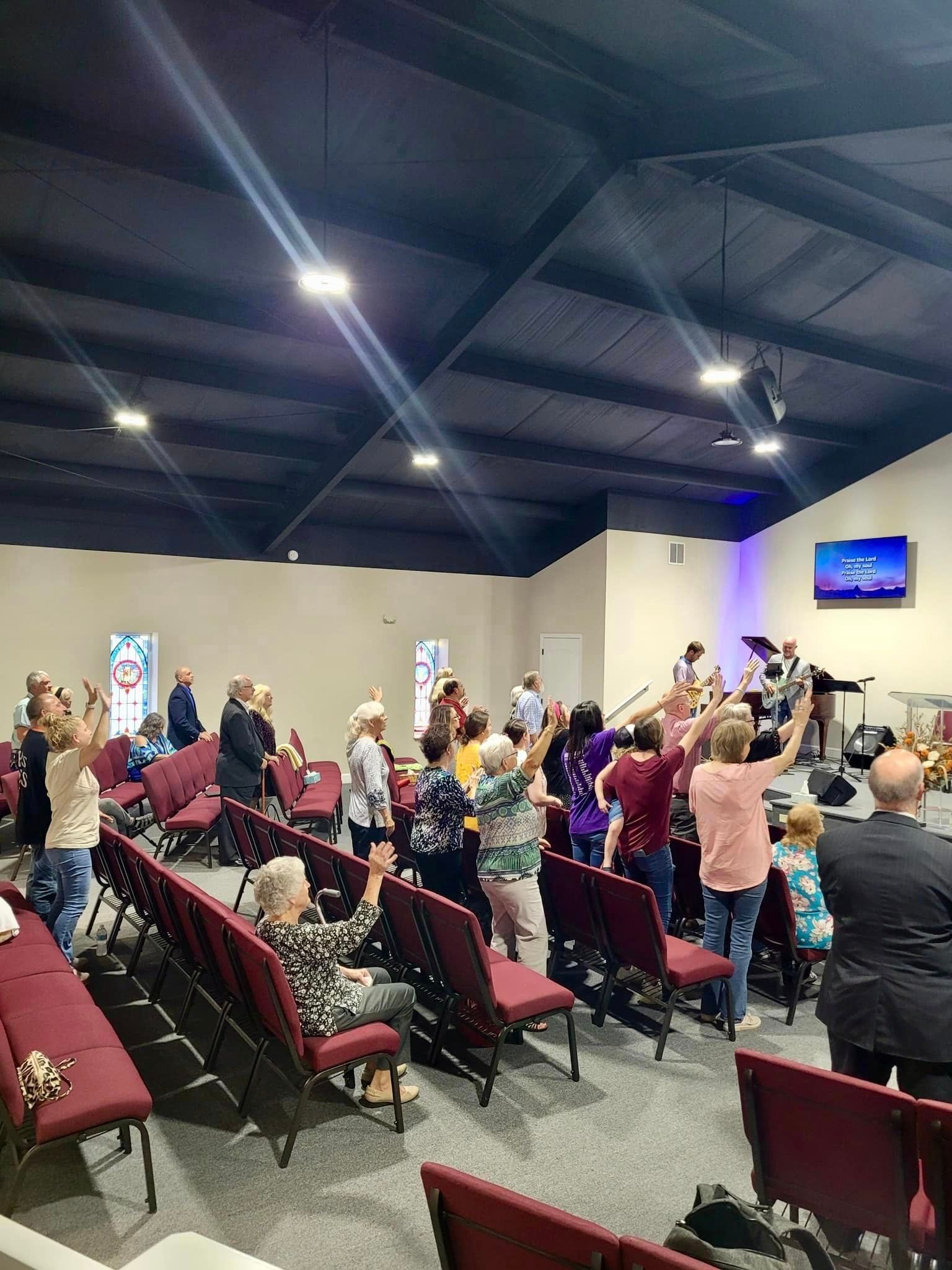 A large group of people are standing in a church.