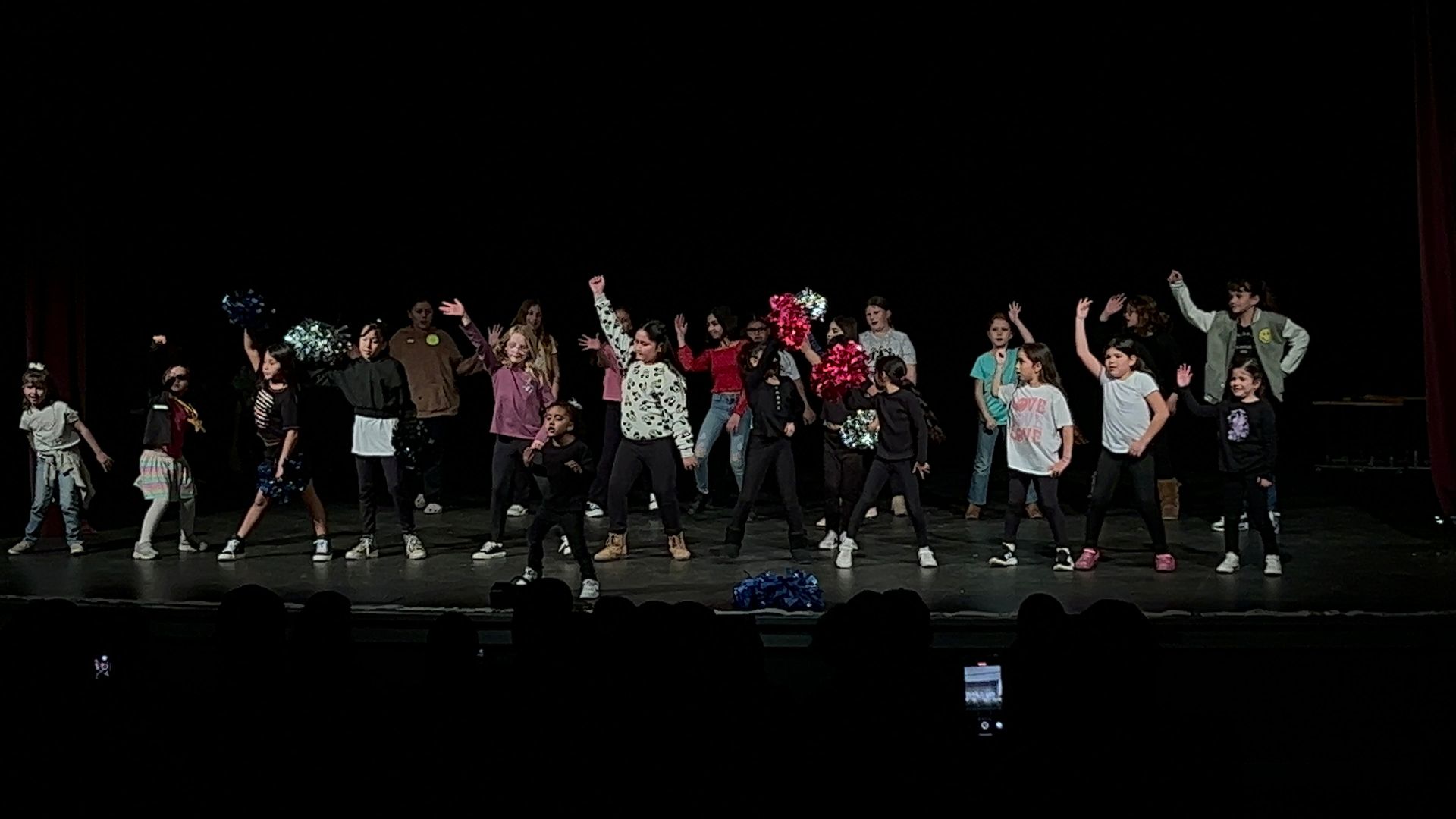 A group of children are dancing on a stage.