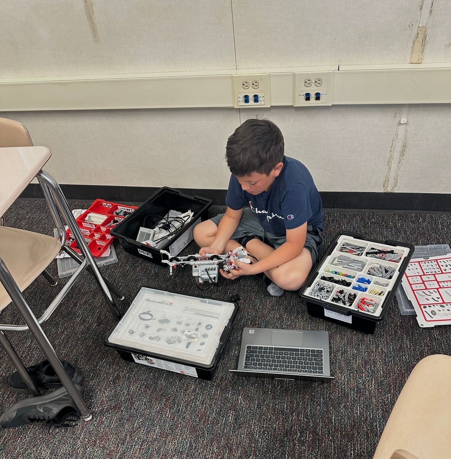 A young boy is sitting on the floor playing with lego blocks