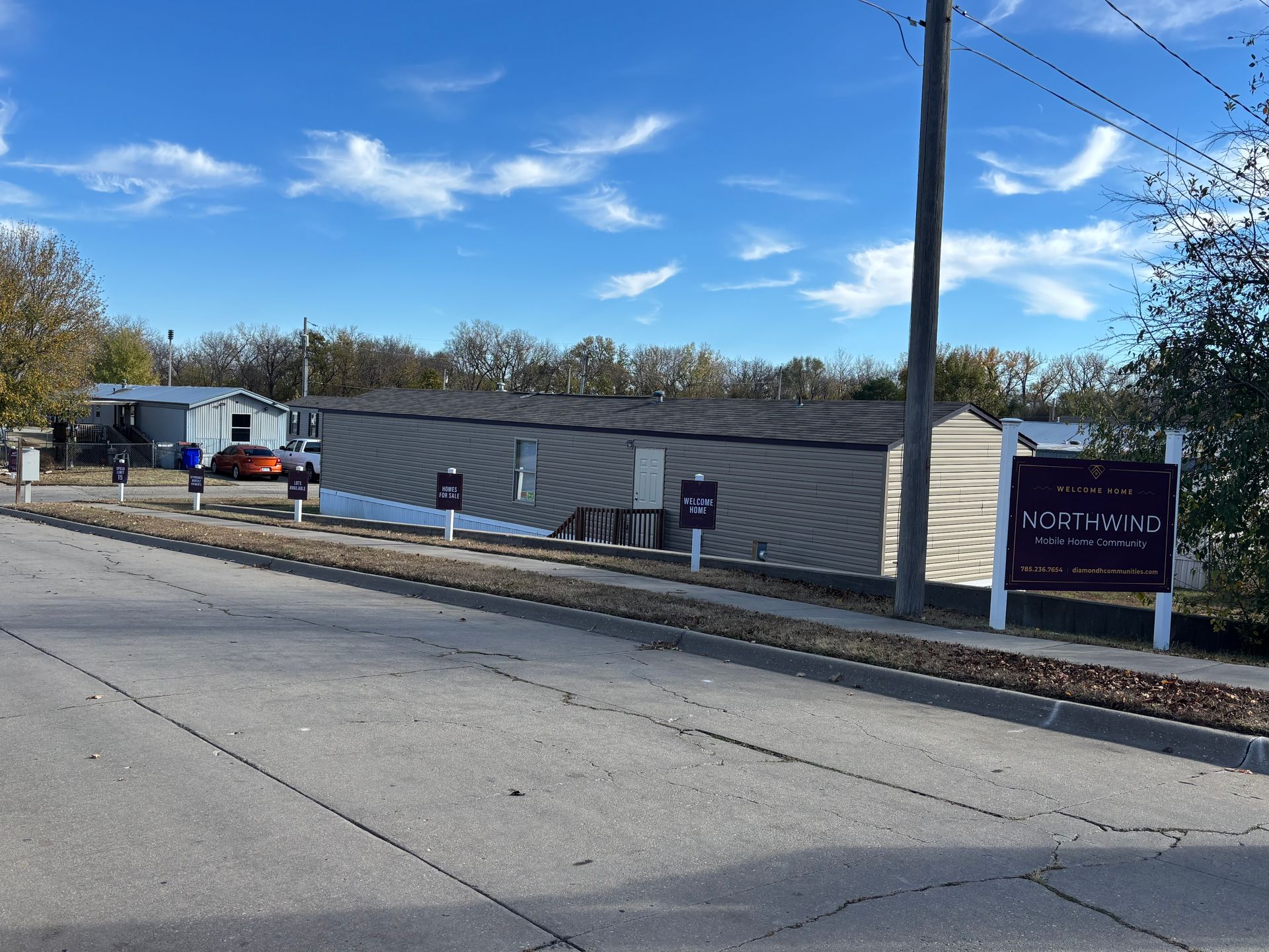 A mobile home park with a purple sign that says ' rental ' on it