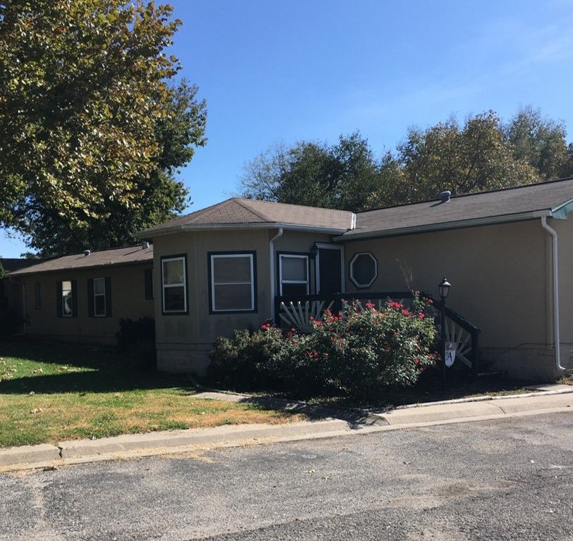 A house with a lot of windows and bushes in front of it