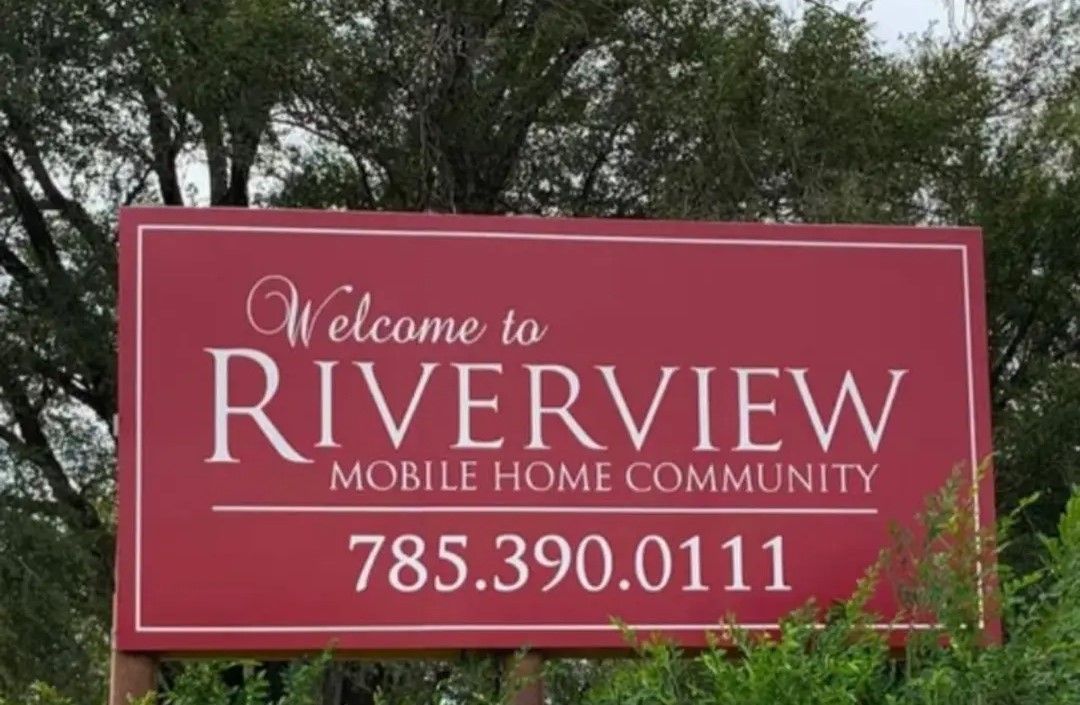 A red sign that says welcome to riverview mobile home community