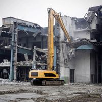 excavator tearing down a large building
