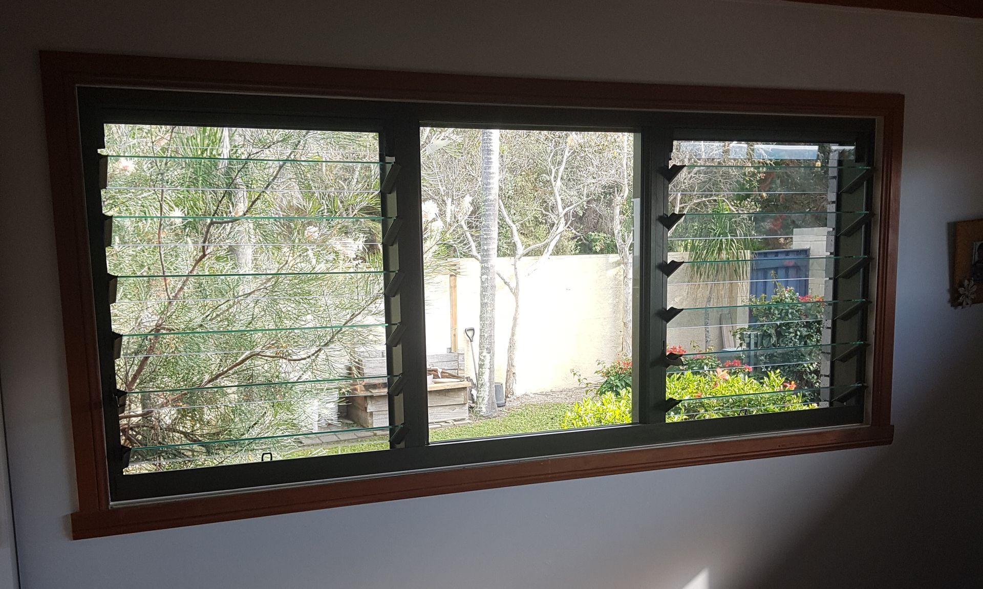 A large crystal window in a room with a view of a garden.