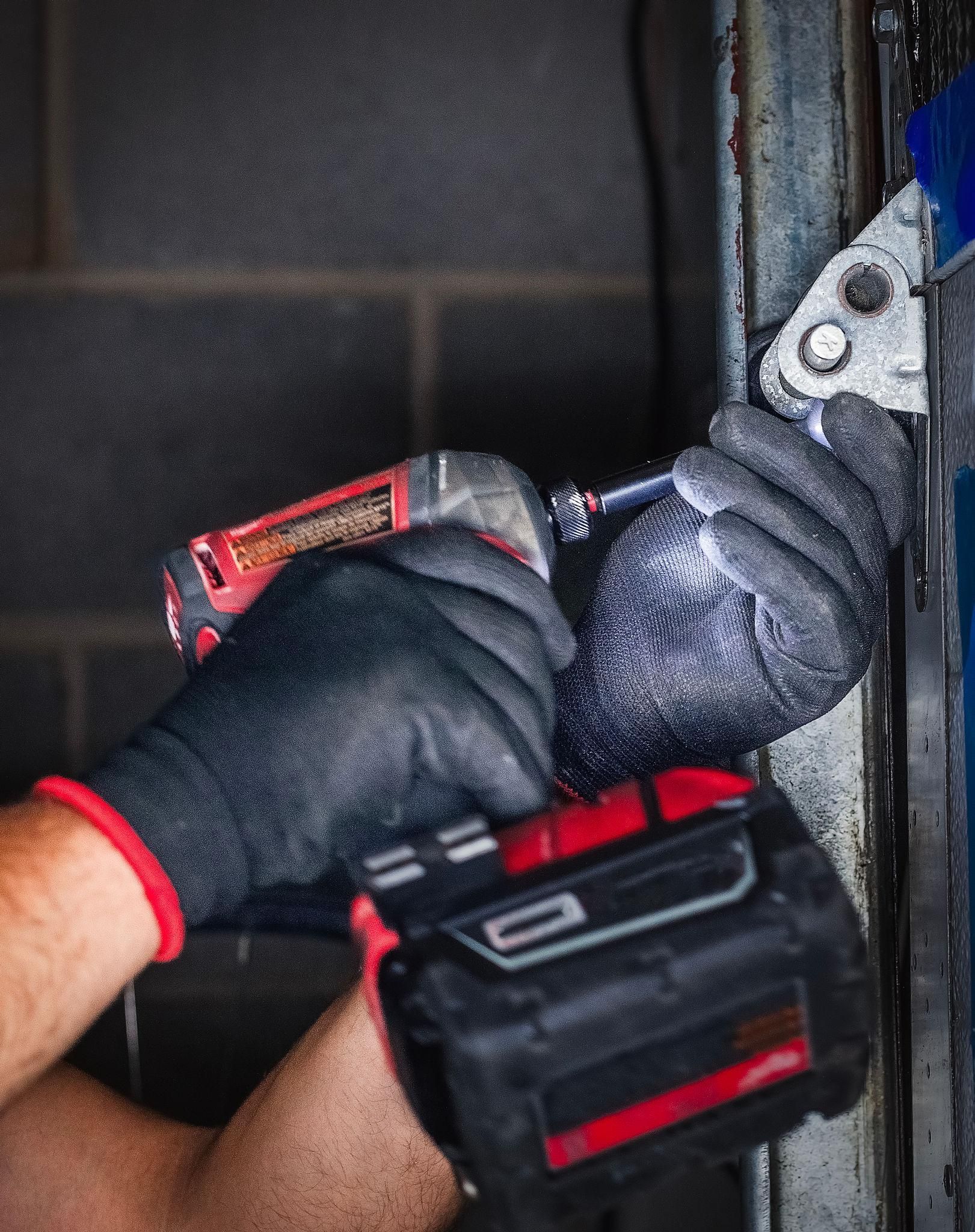 Technician repairing a faulty garage door in a residential home in Noosa