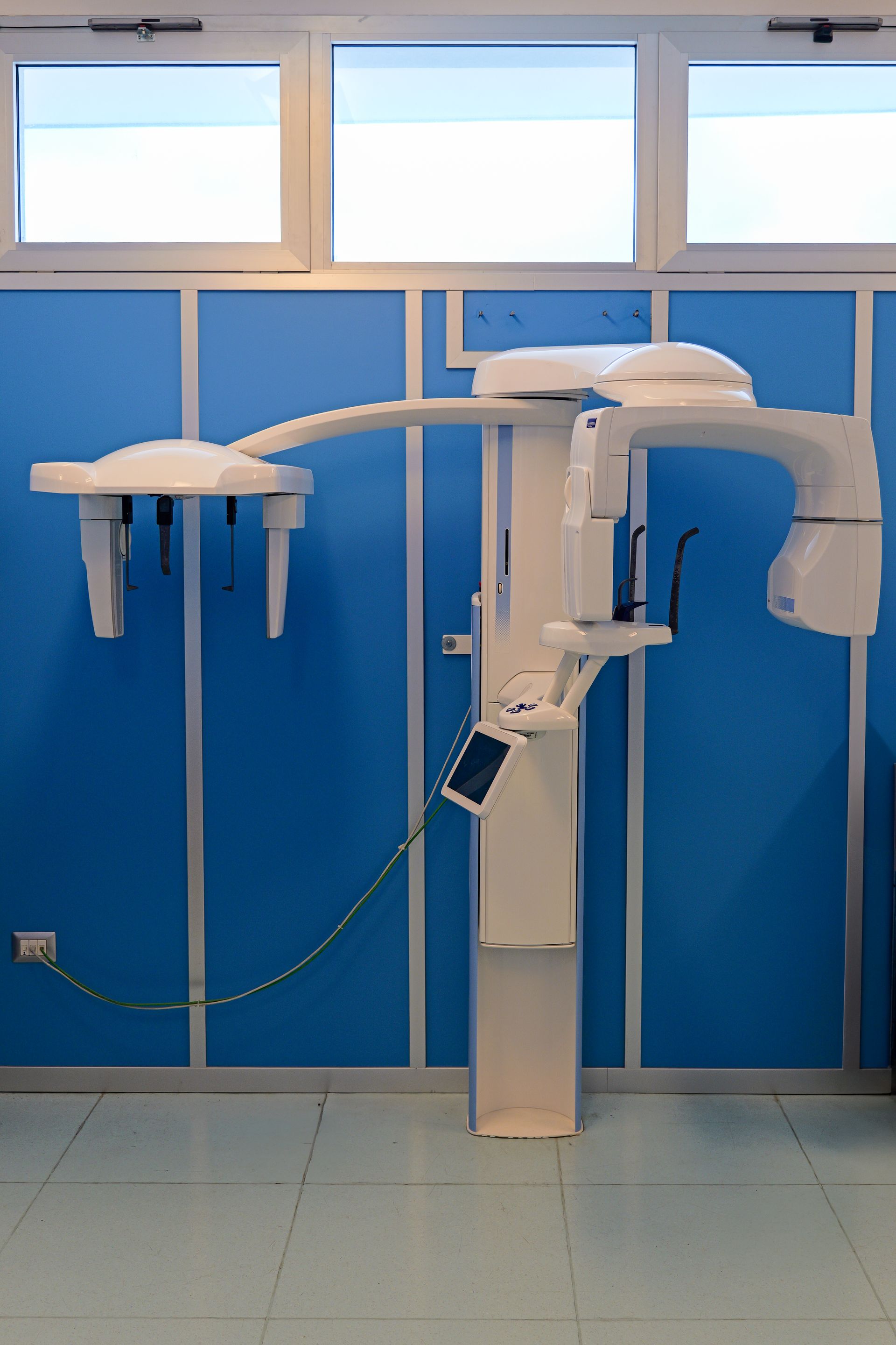 Tre operatori sanitari sono in consultazione alla reception; uno indossa un camice bianco, gli altri due un camice bianco.