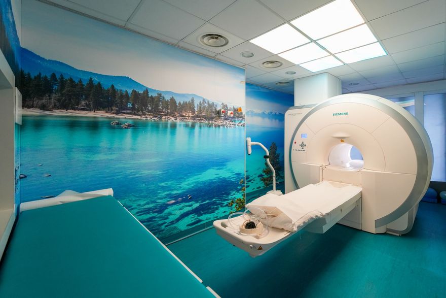 Scanner TC in una stanza blu con un letto per il paziente.