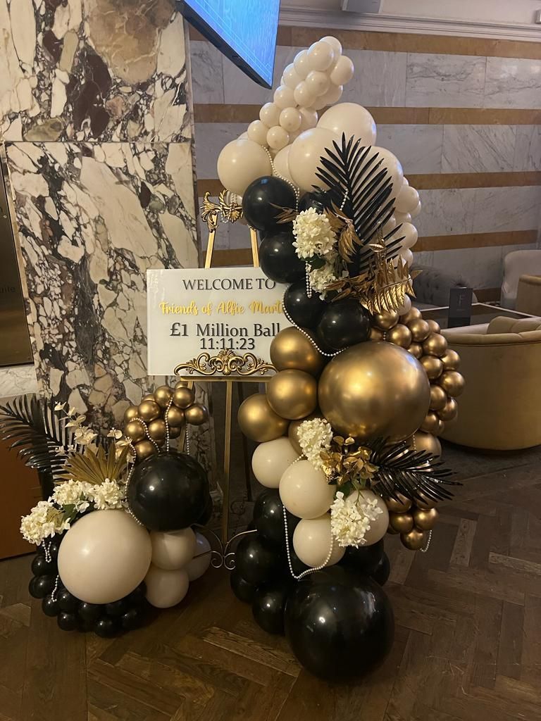 A bunch of balloons are sitting on a table in a room for the Friends of Alfie Martin £1 Million Ball