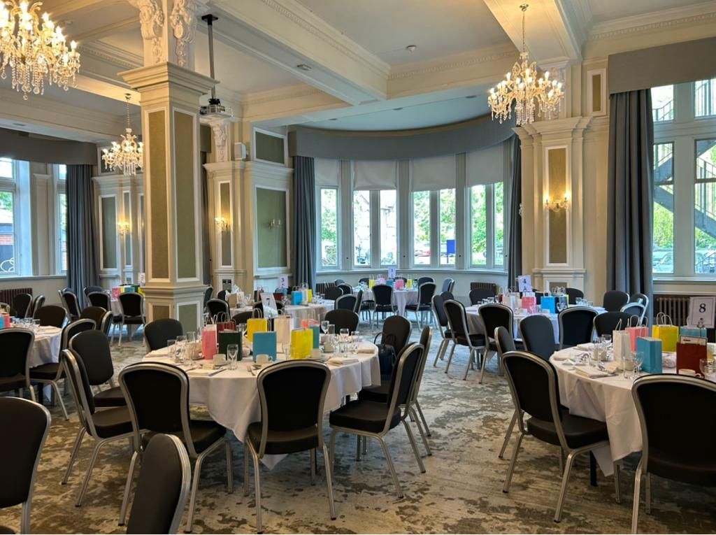 A large room with tables and chairs set up for a Friends of Alfie Martin charity event