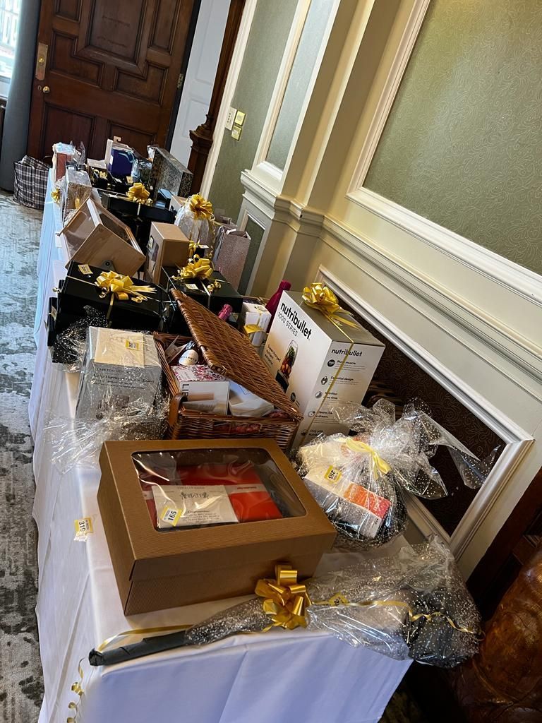 A table with a lot of boxes and baskets on it  at a Friends of Alfie Martin charity lunch