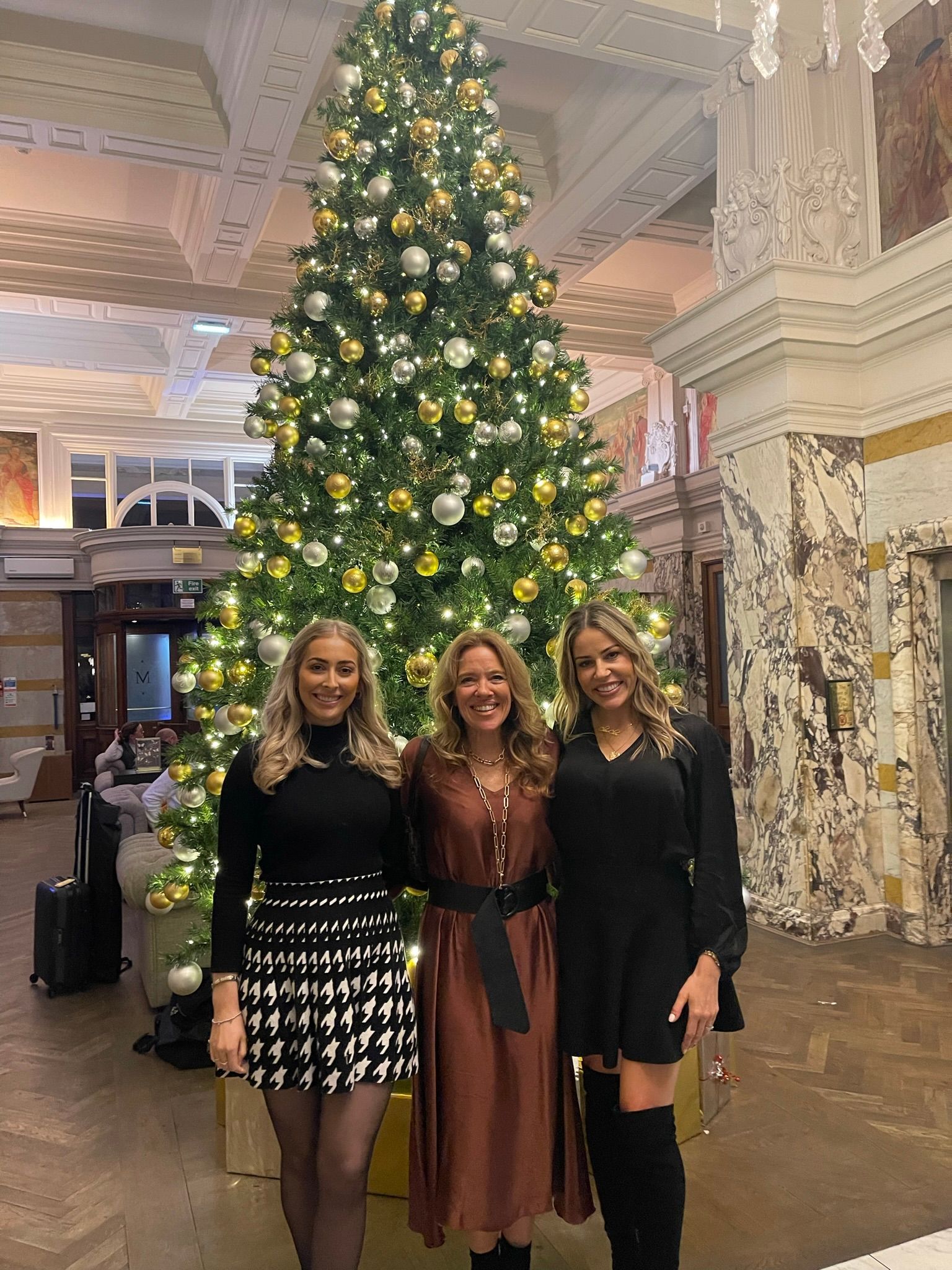 Fiona and guests posing for a picture in front of a christmas tree at a Friends of Alfie Martin charity event