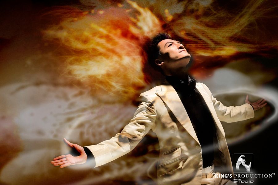 身穿奶油色西裝的男子張開雙臂，抬頭看著火熱旋轉的背景。