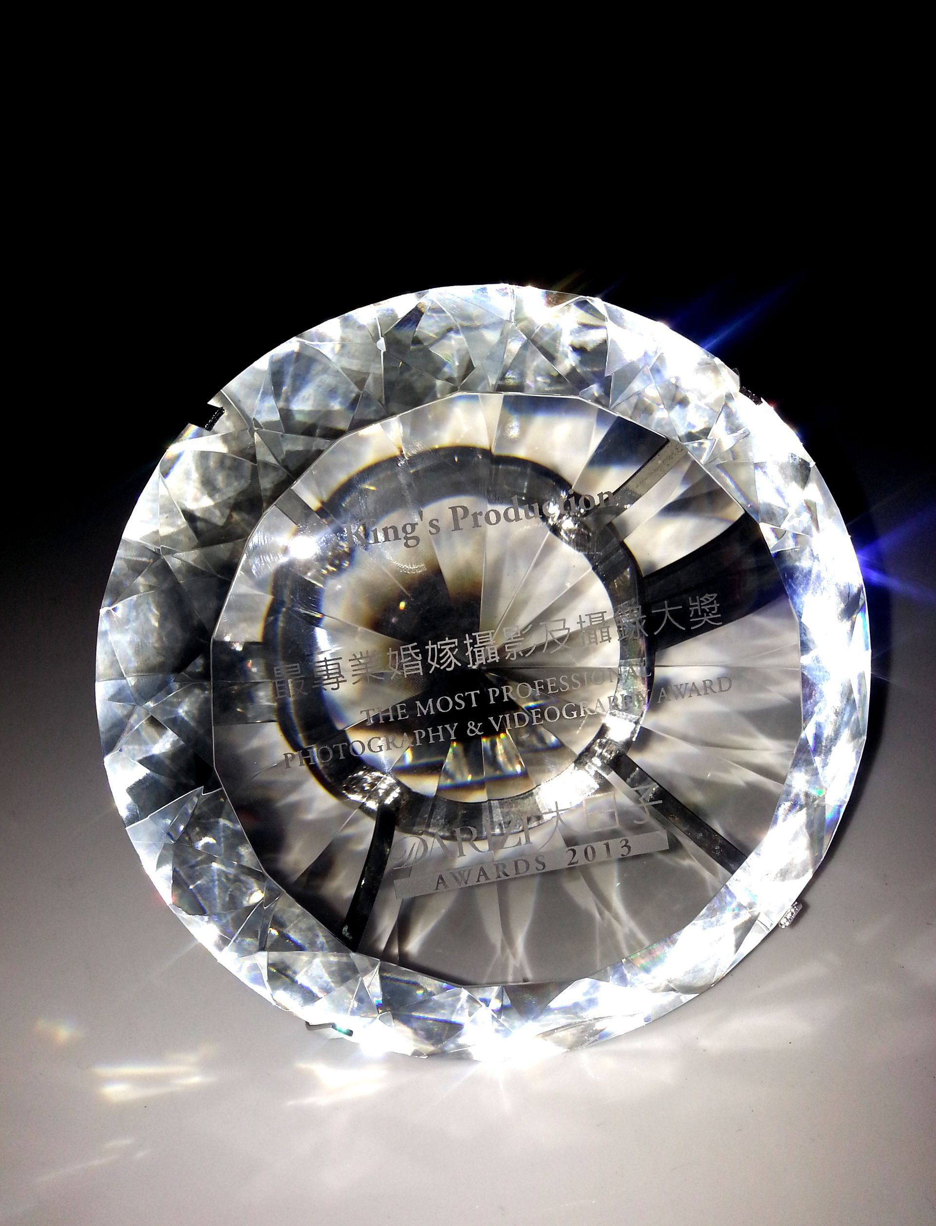 水晶獎,圓形,帶有文字,反射光線,背景為深色。