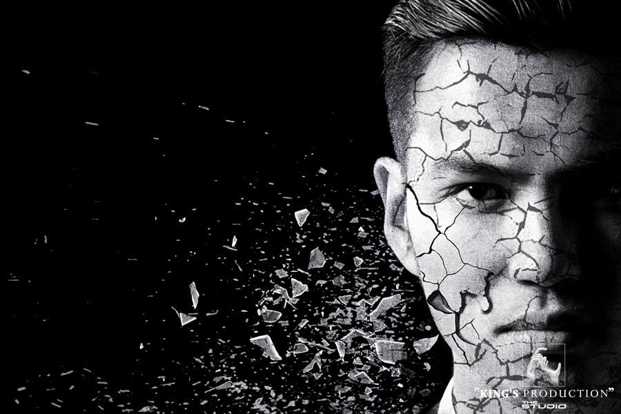 男人的臉部皮膚出現裂紋，在黑色背景下部分崩解。