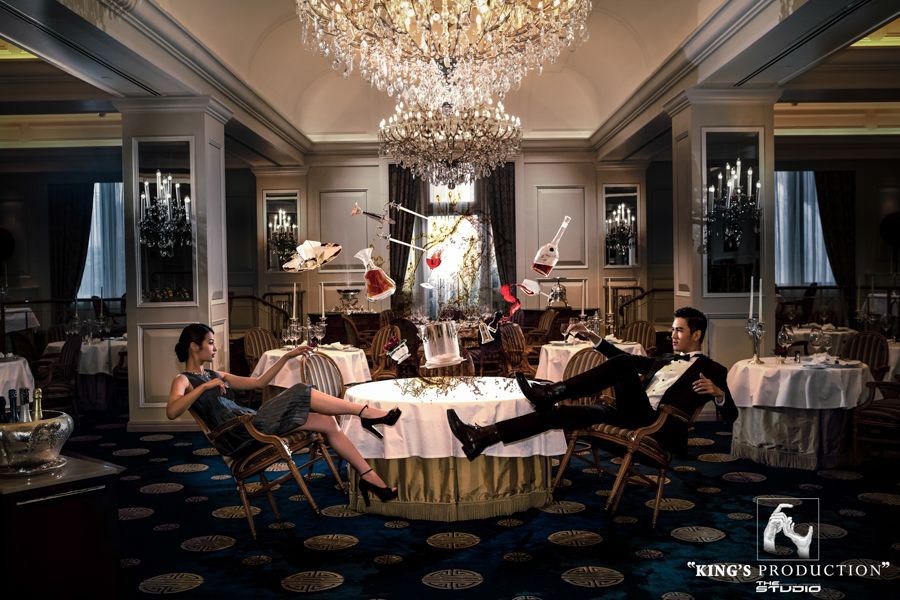 一對夫婦在一間高檔餐廳的桌子周圍漂浮，卡片和物品漂浮在空中。