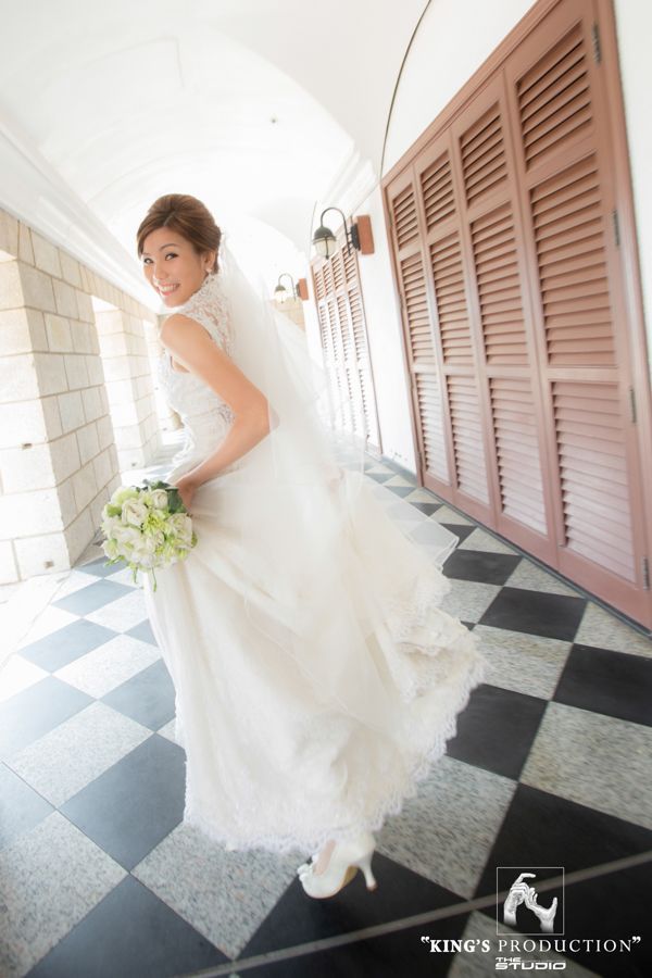 身著婚紗的新娘，微笑著，走著，回頭看。戶外，格子地板，白色禮服。