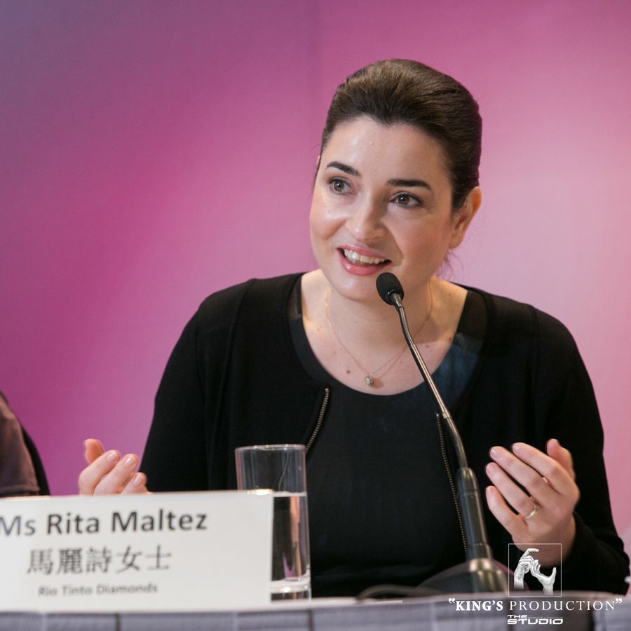 麗塔·馬爾特茲女士在一次會議上發言。她身著黑色服裝，身穿柔和的光芒。