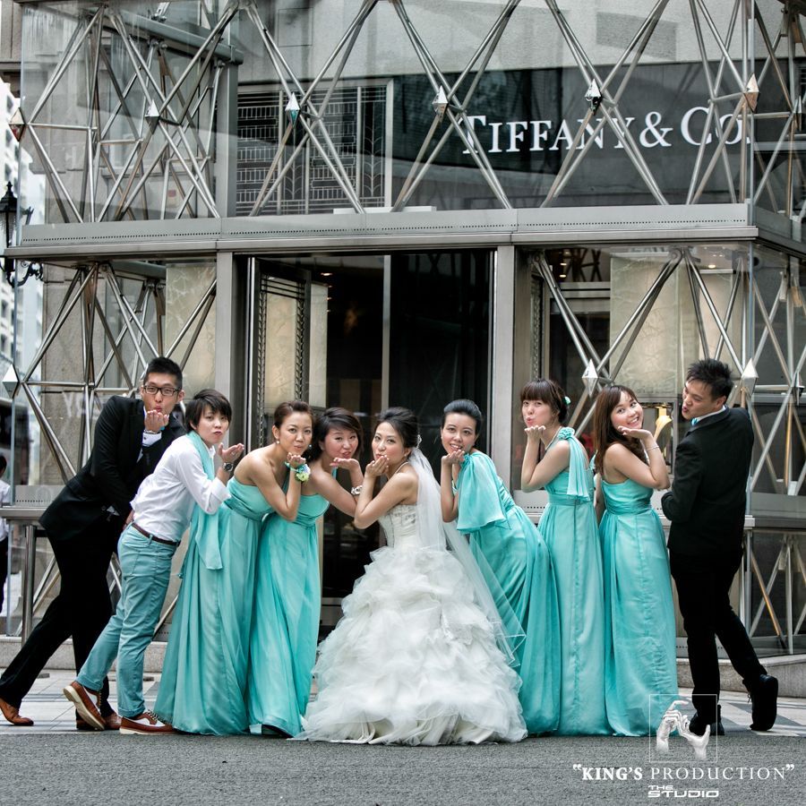 婚禮派對在蒂芬妮 (Tiffany & Co.) 商店前擺姿勢：新娘、身穿綠松石色禮服的伴娘、伴郎。