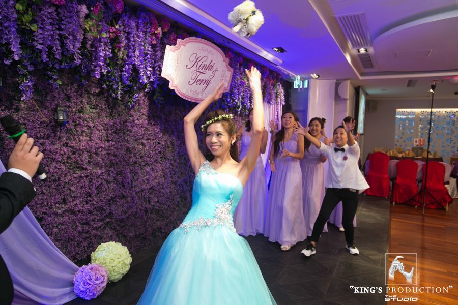 新娘在婚宴上拋花束，伴娘們在一旁觀看。