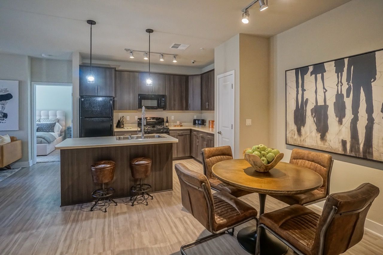 Open-concept kitchen and dining area with island, pendant lights, and round table.