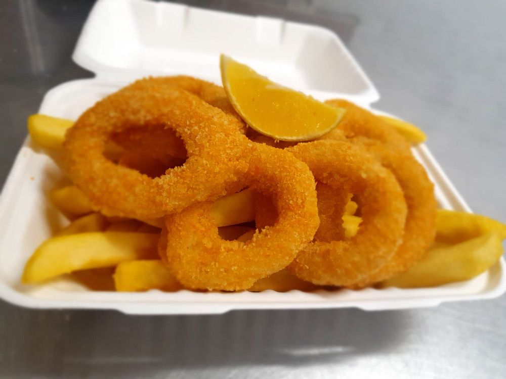 Crumbed Squid Rings Served with Lemons on a Plate — Local Seafood Shop in Portsmith, QLD