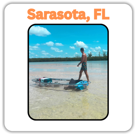 man walking next to clear kayak on a sand