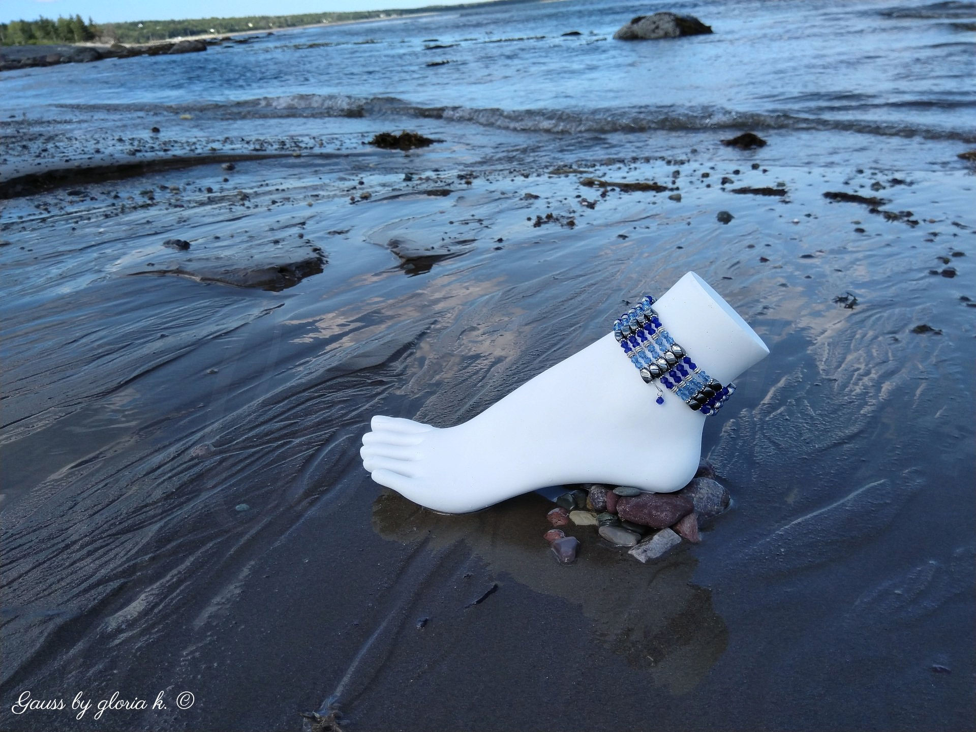 Blue Storm magnetic hematite wrap anklet surrounded by indigo blue ocean tide
