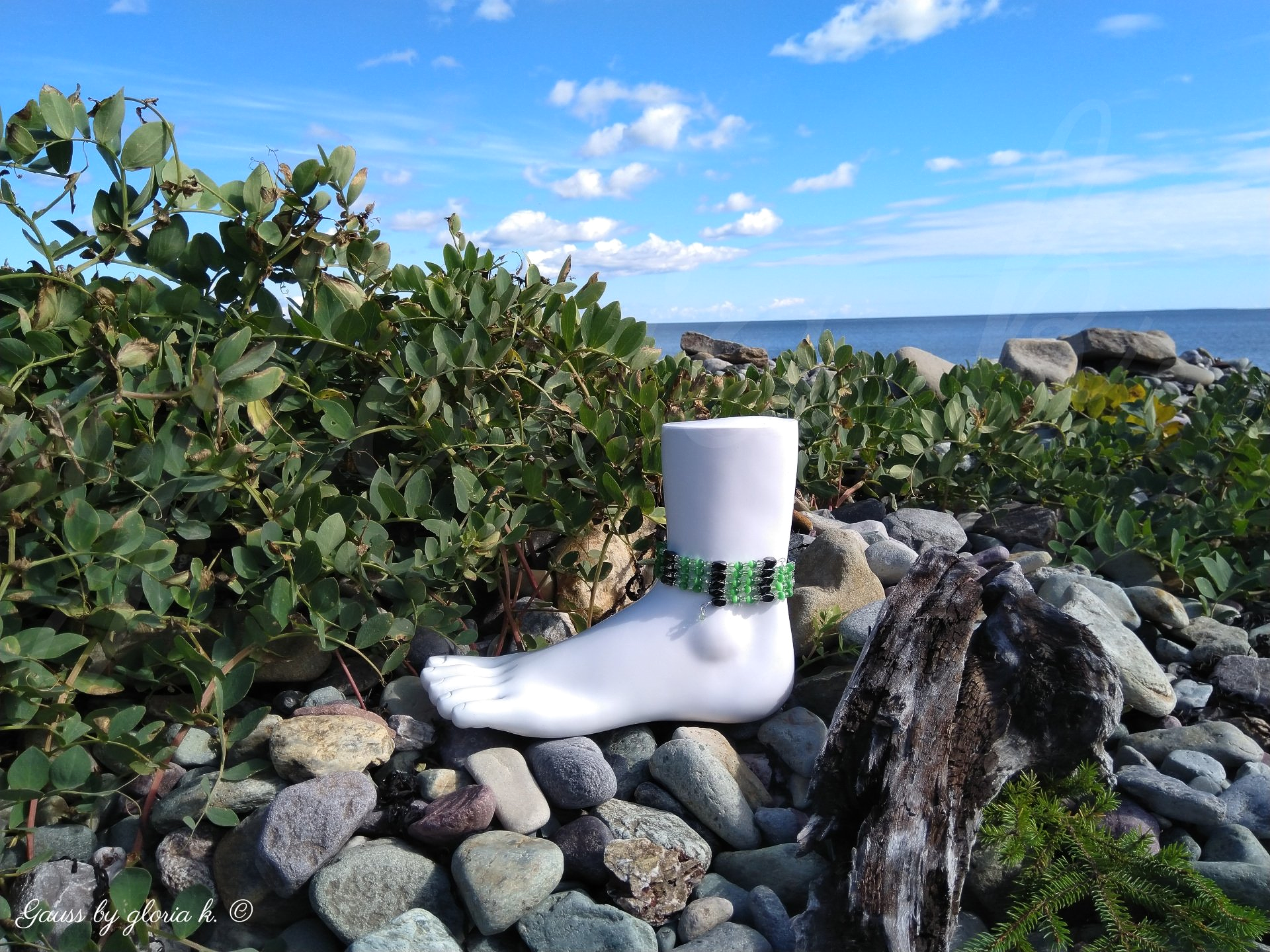 Irish Green magnetic hematite wrap anklet with green foliage on rocky shore