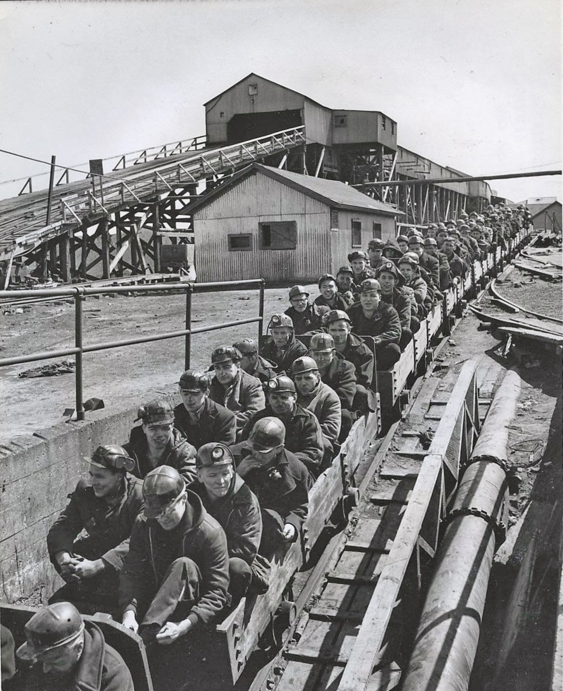 Coal miners on transportation carts going down to the mine, 1960's.