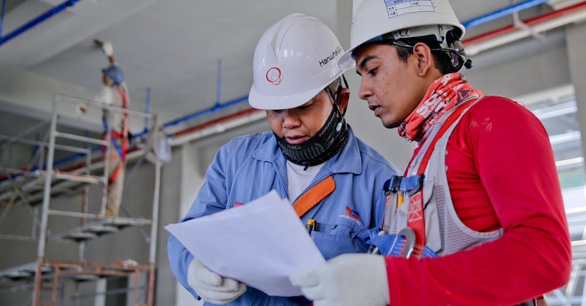 Two construction workers are looking at a piece of paper.