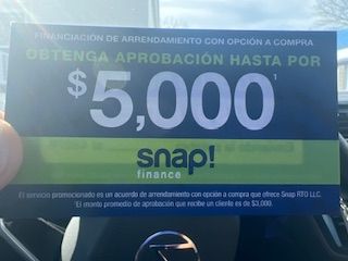 A person is holding a snap finance card that says $ 5,000