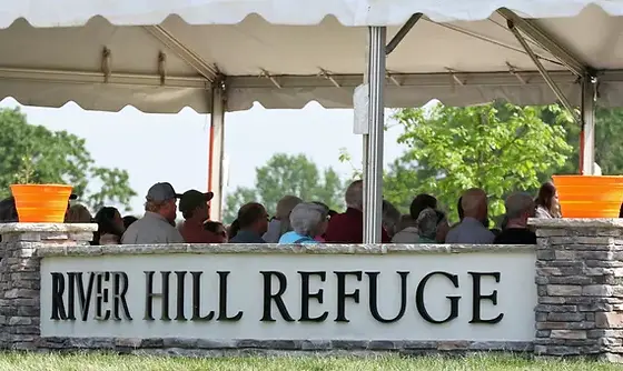 A group of people are gathered under a tent at River Hill Refuge - Hickory, NC - Giving Kids Hope Fo