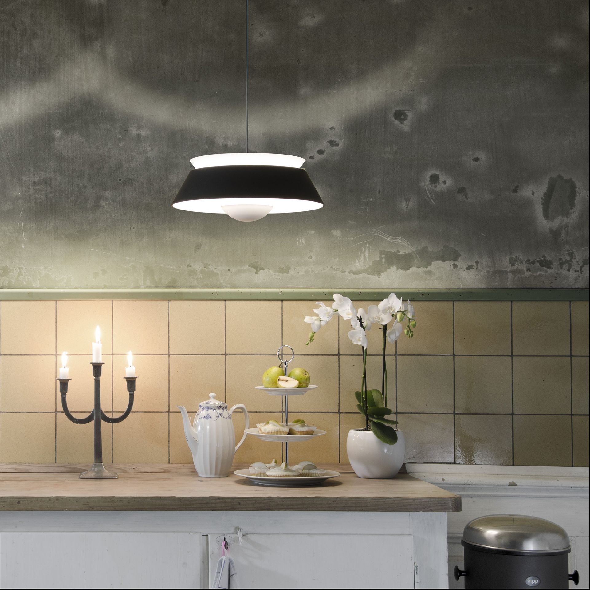 A kitchen with a few candles and flowers on the counter