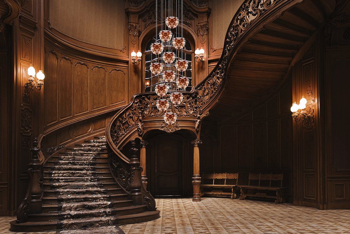 A large staircase in a building with a chandelier hanging from the ceiling.