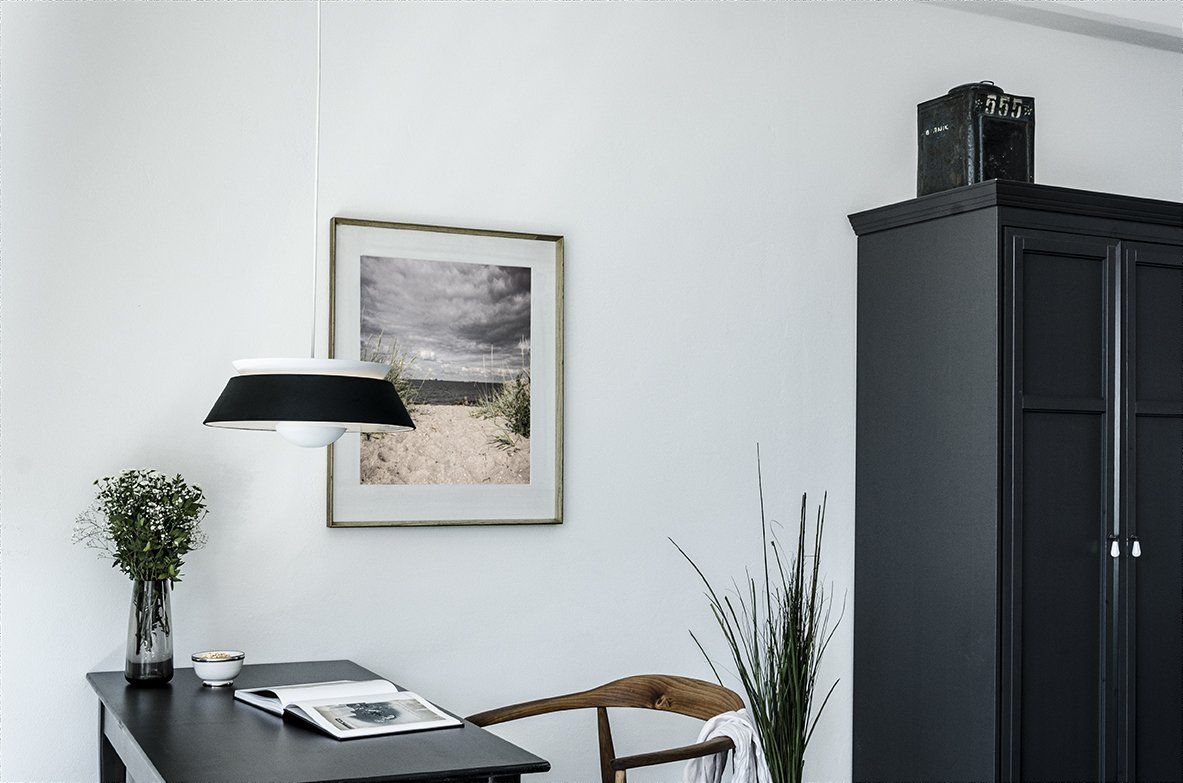 There is a picture on the wall above the desk and chair.