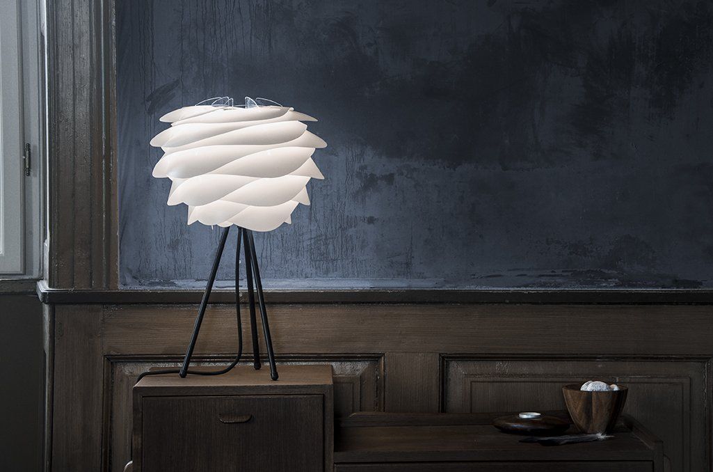 A lamp is sitting on top of a wooden table in a room.