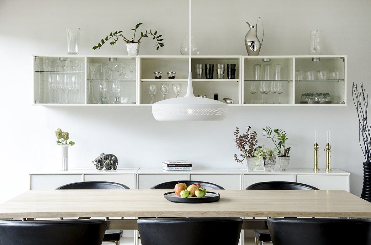 A dining room table with a bowl of apples on it