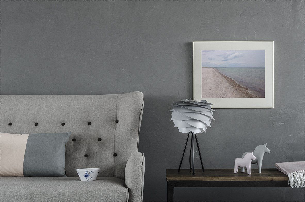 A living room with a couch , table , lamp and a picture on the wall.