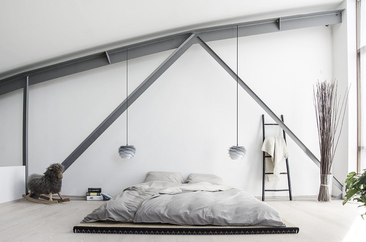 A bedroom with a bed and a ladder on the floor