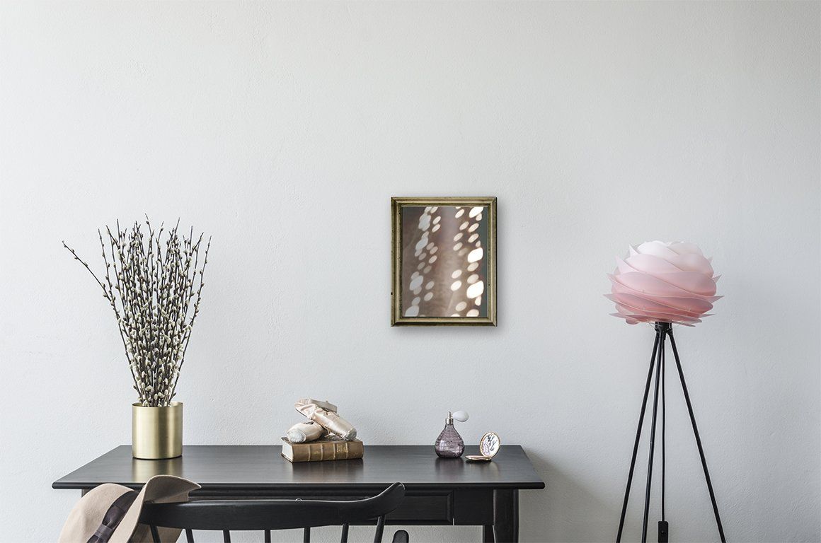 A room with a table , chair , lamp and a picture on the wall.