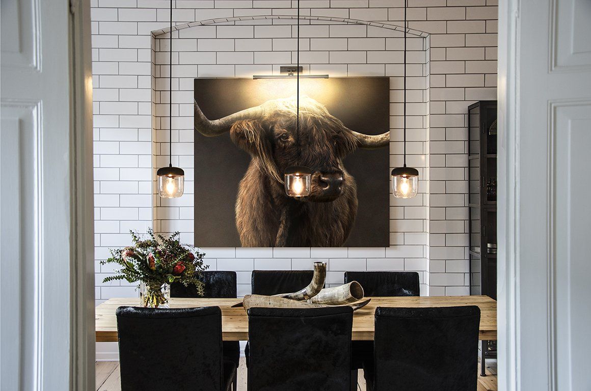 A dining room with a picture of a bull on the wall