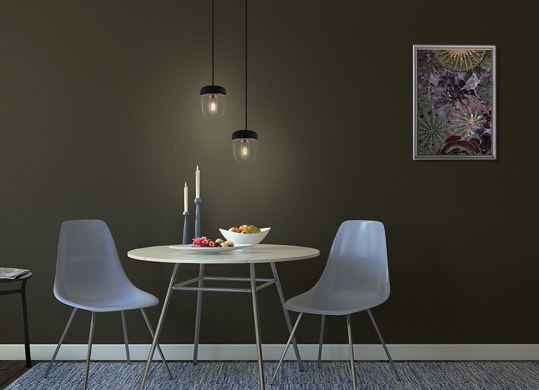 A dining room with a table and chairs and a picture on the wall.