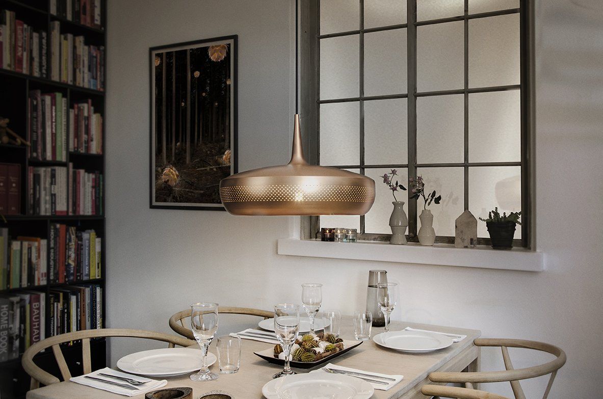 A dining room with a table and chairs and a window.