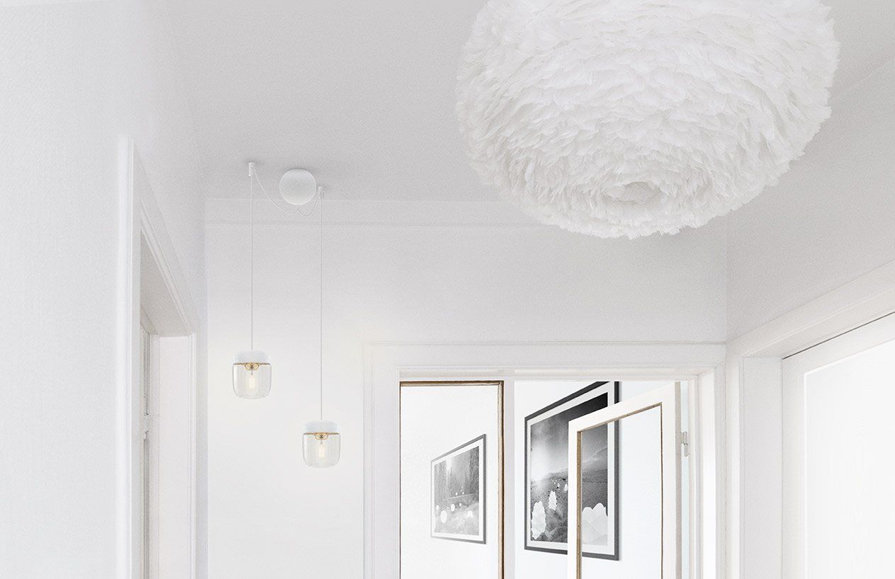 A white hallway with a white feather lamp hanging from the ceiling.