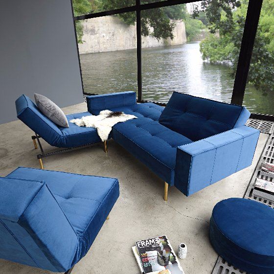 A living room with a blue couch and two blue chairs